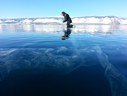 Baikal transparent ice and icy cave explorer